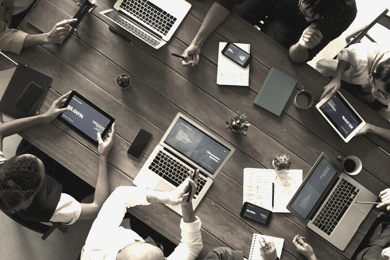 Mesa de reunión con herramientas de trabajo y distintas perspectivas